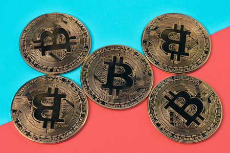 Bunch of golden bitcoins isolated on blue and red background.の写真素材