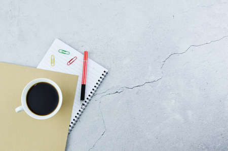 Top view of coffee, notebooks, pen and paper clips with copy space.の写真素材