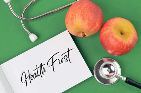 Stethoscope, apples and memo note written with HEALTH FIRST.の写真素材