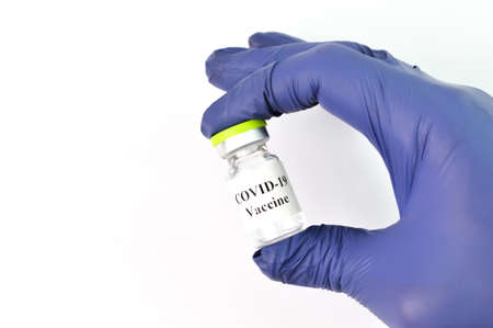 Hand holding Covid-19 bottle vaccination over white background