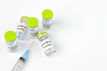 Covid-19 bottle vaccination and syringe over white backgroundの写真素材