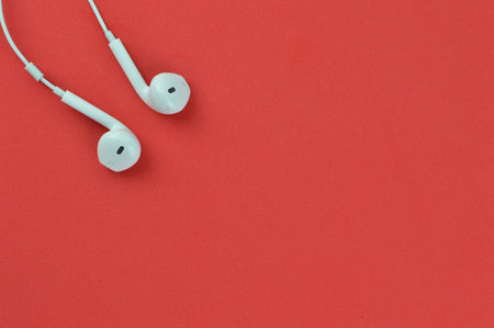 Top view of earphones over red background with copy spaceの写真素材