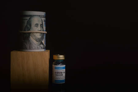 Coronavirus Covid-19 bottle vaccination and money banknote over black background