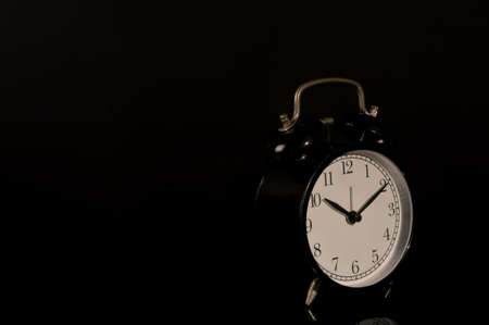 Alarm clock isolated on black background with copy spaceの写真素材