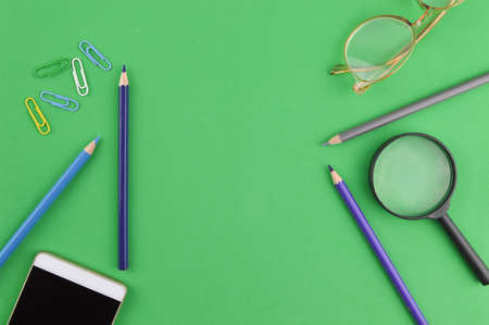 Stationery tools over green background with copy space.の写真素材