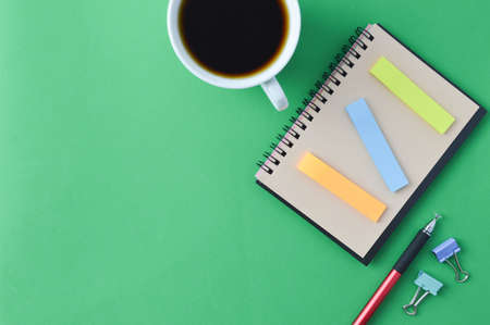 A cup of coffee, notebook and pen with copy space.