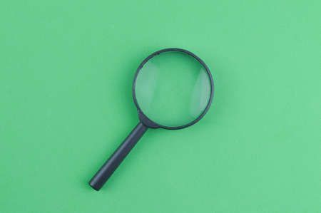 Top view of magnifying glass over green backgroundの写真素材