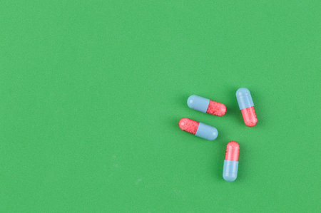 Pill capsules over green background with copy space.の写真素材