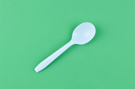 White spoon over green backgroundの写真素材