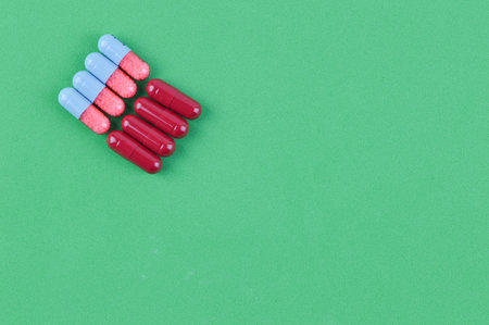 Pill capsules over green background with copy spaceの写真素材