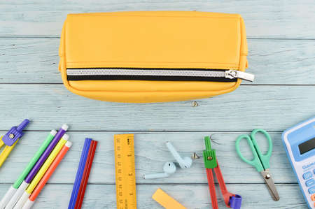Top view of pencil case and stationery tools over wooden backgroundの写真素材