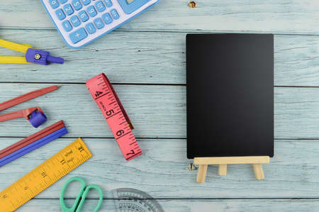 Top view of stationery tools and blackboard with copy space over wooden background.の写真素材