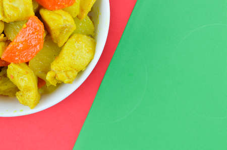 The crop image of turmeric chicken over green and red background.の写真素材