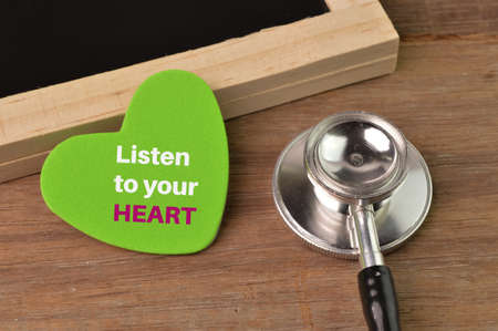 Stethoscope, chalkboard and love shape written with LISTEN TO YOUR HEART.の写真素材
