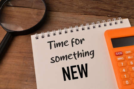 Magnifying glass, calculator and notebook written with TIME FOR SOMETHING NEWの写真素材