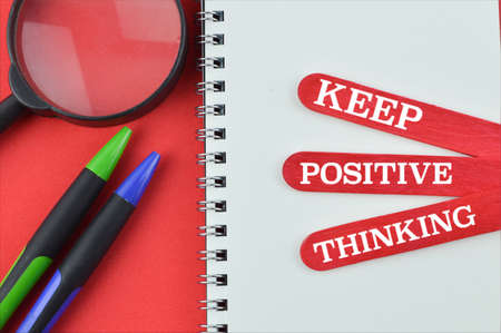 Notebook and ice cream sticks written with KEEP POSITIVE THINKING.の写真素材