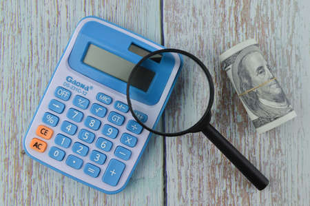 Klang,Malaysia: March 28, 2021-Top view of calculator, eyeglasses and money banknote over wooden backgroundのeditorial素材