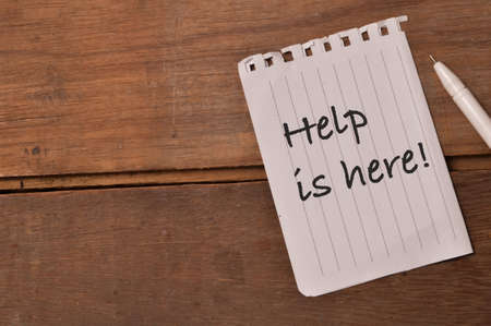 Pen and white paper written with text HELP IS HERE!の写真素材