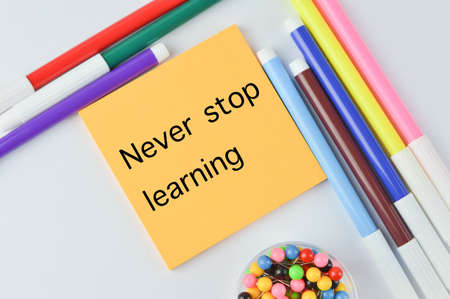 Colorful pen colors and memo note written with NEVER STOP LEARNINGの写真素材