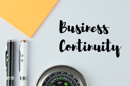 Pen, compass and notebook over white background written with BUSINESS CONTINUITYの写真素材