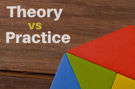 Colorful wooden blocks over wooden background written with THEORY VS PRACTICEの写真素材