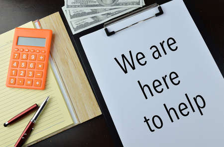 Top view of white paper written with text WE ARE HERE TO HELP