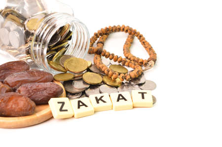 ZAKAT word with stack of coins, prayer beads and dates over white backgroundの写真素材