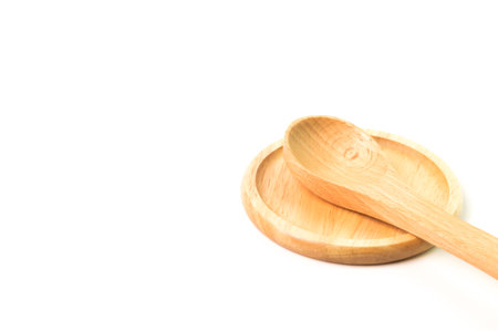 Round wooden plate and spoon isolated on a white backgroundの写真素材