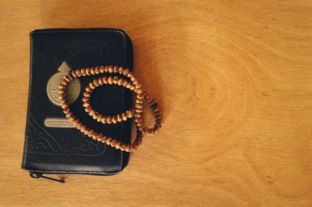 Top view of the Holy Quran or Koran with rosary beads isolated on a wooden background. Islamic concept.の写真素材