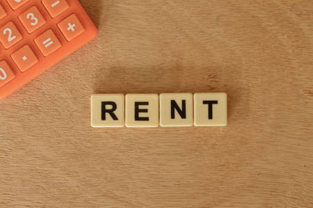 Top view of calculator and square letters with text RENT. Business concept.の写真素材