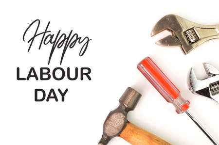 Phrase HAPPY LABOUR DAY written on white background with hammer, wrench and screwdriverの写真素材