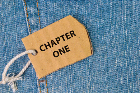 Label tag written with CHAPTER ONE on blue jeansの写真素材
