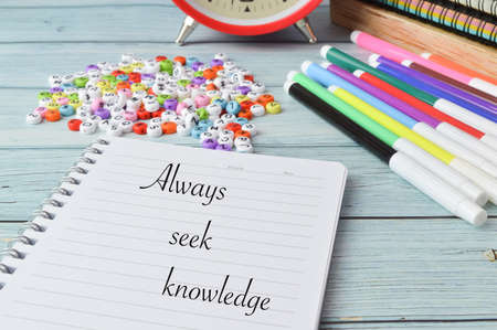 Stationery items and notebook written with ALWAYS SEEK KNOWLEDGE. Business and education concept.の写真素材
