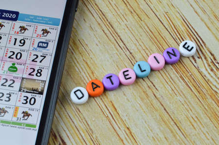 Smartphone with calender app on screen and alphabet beads with text DEADLINE.