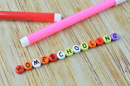 Pen colors and alphabet beads with text HOMESCHOOLING. Education concept.の写真素材
