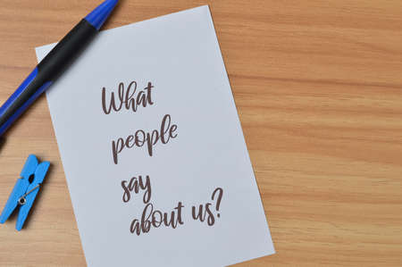 Top view of pen and white paper written with WHAT PEOPLE SAY ABOUT US?の写真素材
