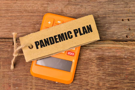 Top view of calculator and label tag written with PANDEMIC PLAN.
