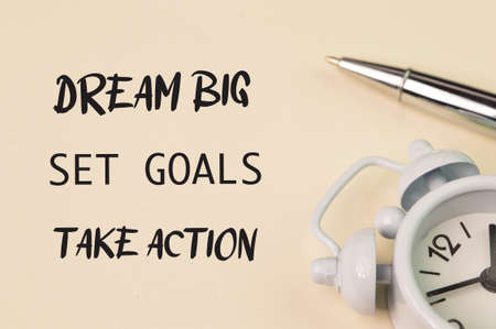 Phrase DREAM BIG, SET GOALS and TAKE ACTION written on yellow background