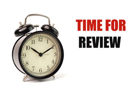 Alarm clock isolated on a white background with text TIME FOR REVIEW.の写真素材