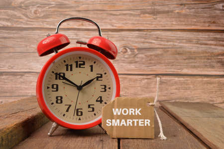 Alarm clock and label tag written with WORK SMARTERの写真素材