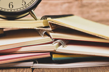 Bunch of notebooks and alarm clock. Conceptual image.