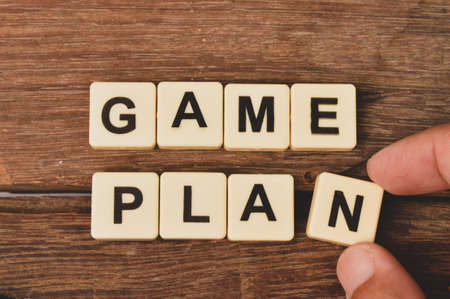 Top view of square letters with text GAME PLAN over wooden background