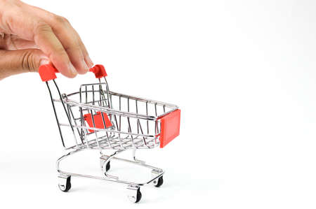 Hand holding shopping cart isolated on a white background. Conceptual image.の写真素材