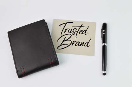 Top view of pen, wallet and memo note written with TRUSTED BRANDの写真素材