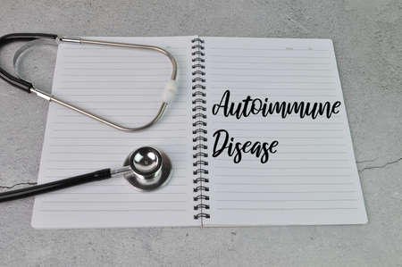 Stethoscope and notebook written with text AUTOIMMUNE DISEASE.の写真素材