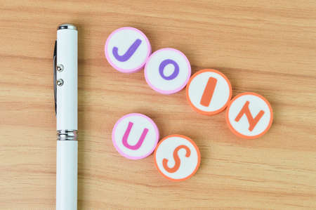 Top view of pen and alphabet letters with text JOIN US.の写真素材