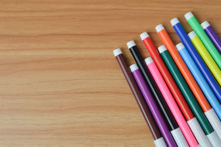 Top view of pen colors on wooden table with copy spaceの写真素材