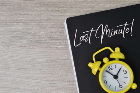 Top view of clock and notebook written with LAST MINUTE.