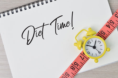 Top view of clock, tape measure and notebook written with DIET TIME!の写真素材