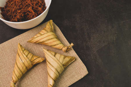 Malay traditional food called as Ketupat rice or Ketupat Palas with serunding. Glutinous rice is wrapped with banana leaf and served during Eid Mubarak.の写真素材